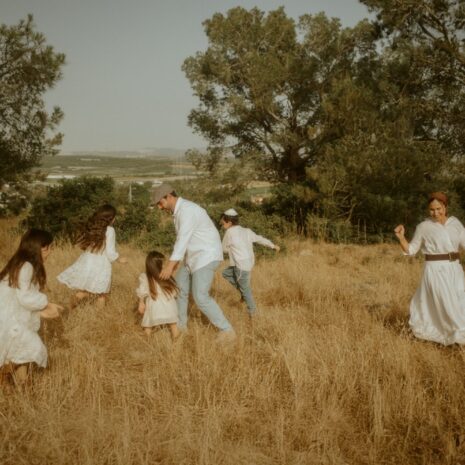 משפחה הולכת בשדה קוצים זהוב באור רך